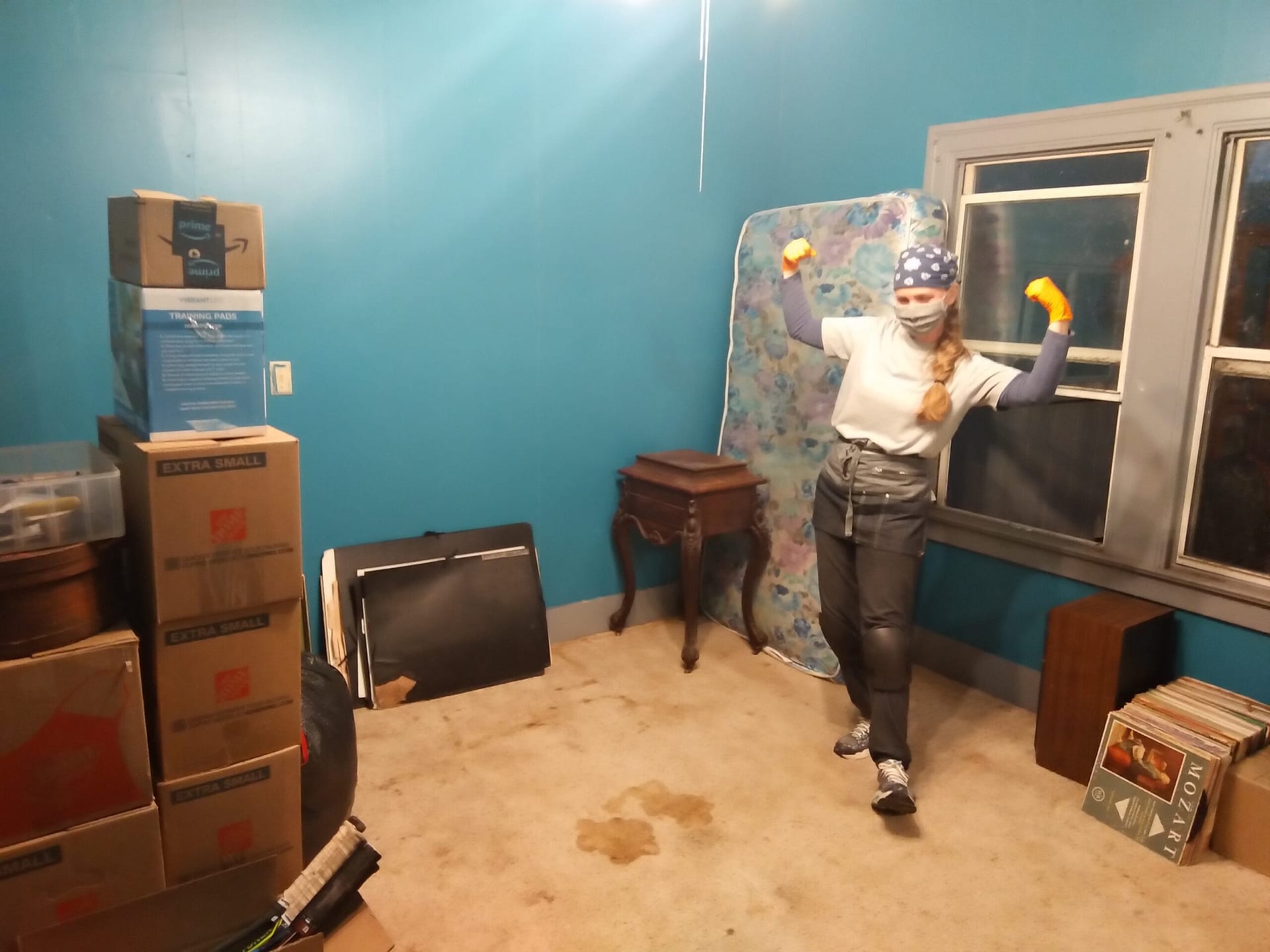 Professional organizer Andrea Lee celebrates progress after clearing the bedroom floor and consolidating belongings into organized groups.