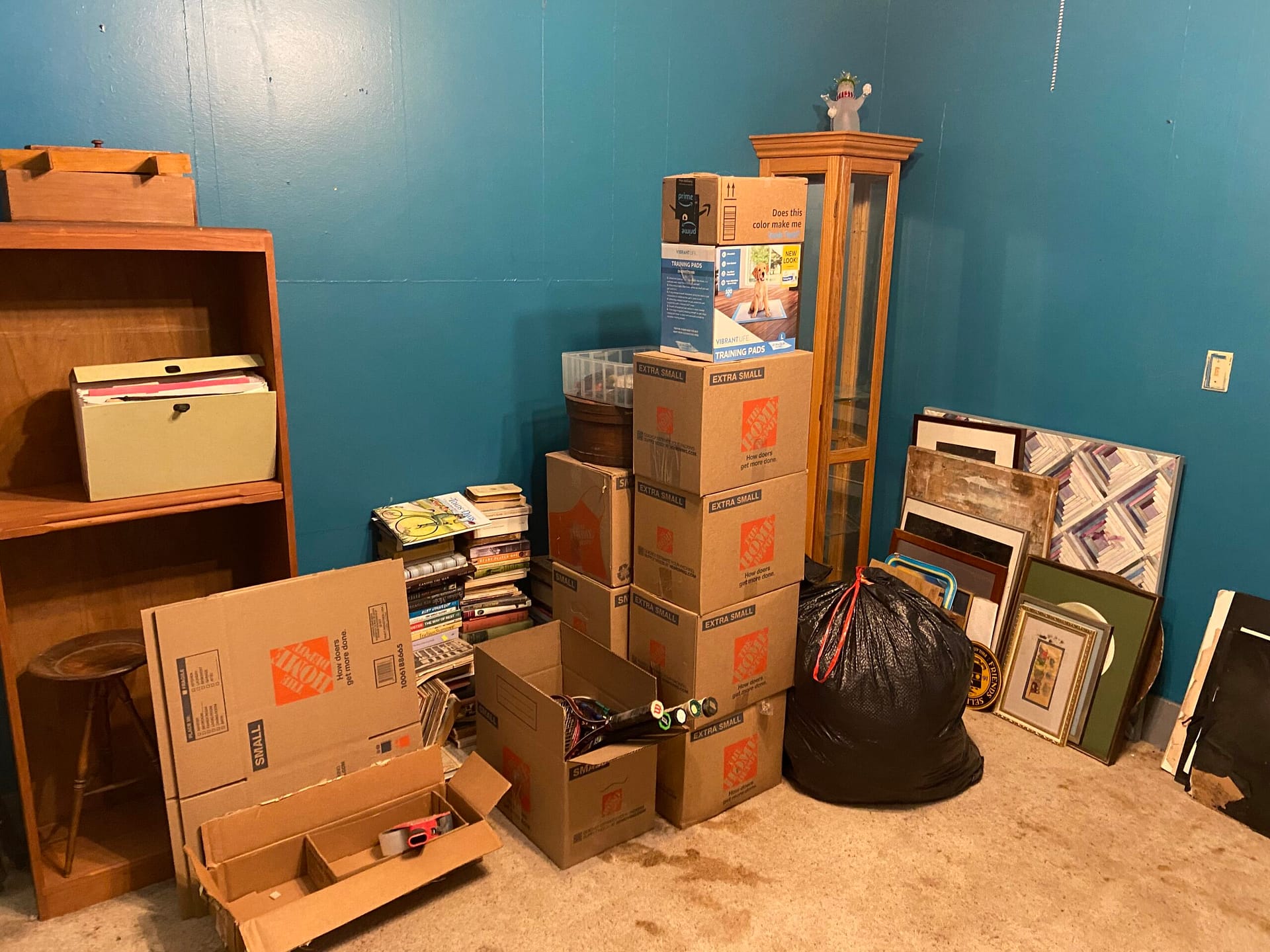 Sorted boxes, books, artwork and household belongings consolidated together as the bedroom organization project nears completion.